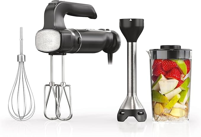 A hand mixer set with attachments: two beaters, a whisk, an immersion blender, and a container filled with chopped fruit.