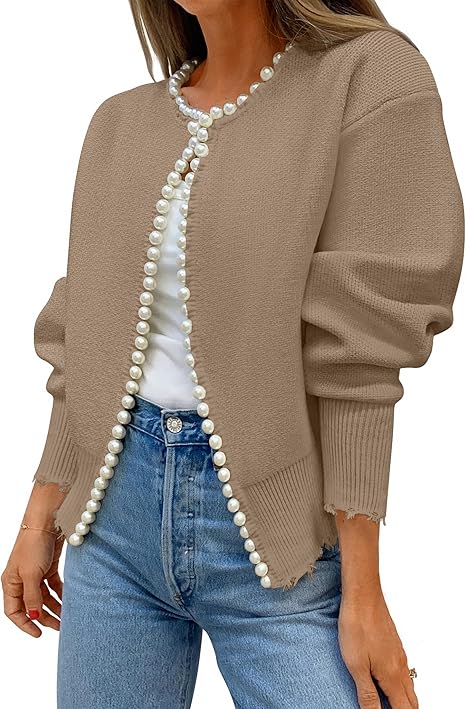 Woman wearing a beige cardigan with white bead trim, white shirt, and blue jeans.