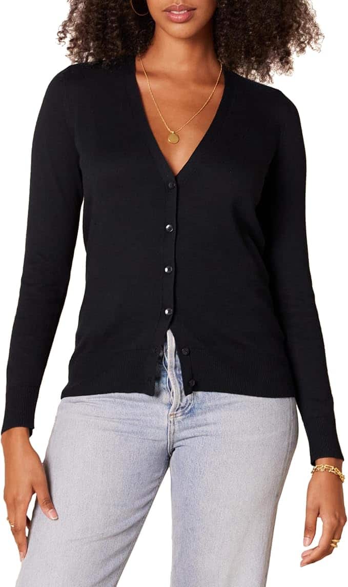 A person wearing a black button-up cardigan with a necklace and light blue jeans.