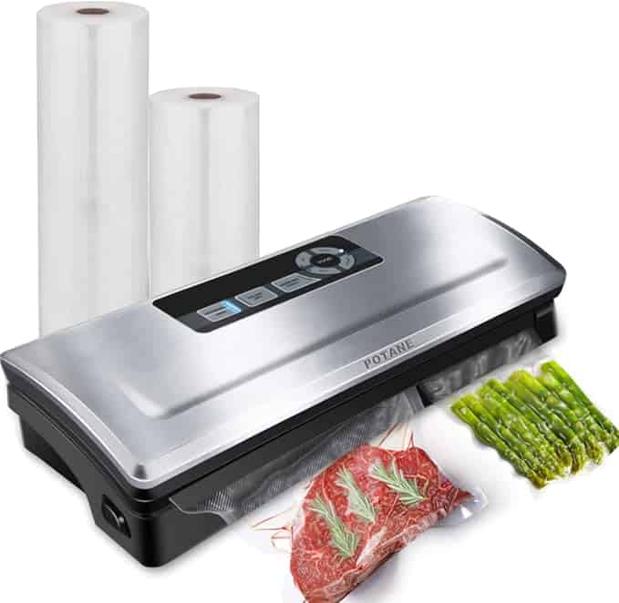 A vacuum sealer with packaged steak and asparagus alongside two rolls of sealing bags.