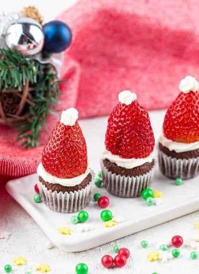 Santa hat mini Christmas muffins on a white plate.