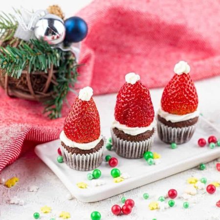 Santa hat mini Christmas muffins on a white plate.