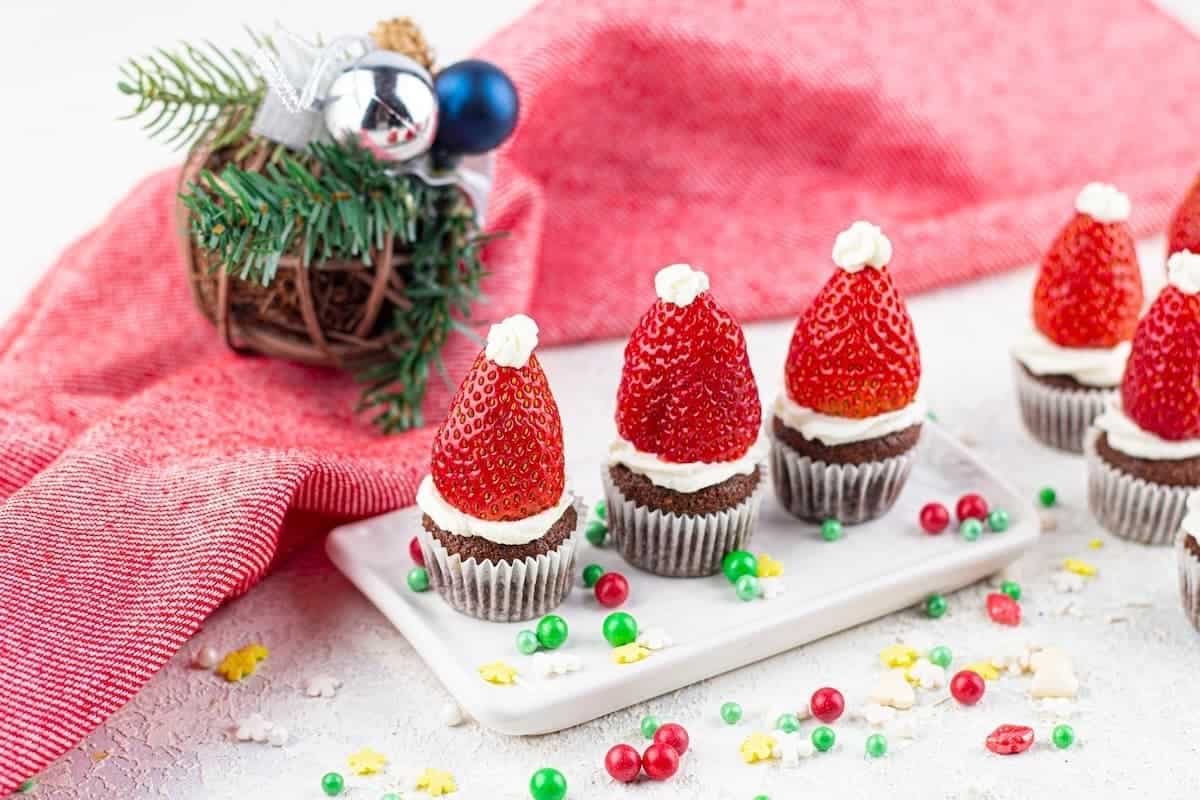 Santa hat mini Christmas muffins on a white plate.