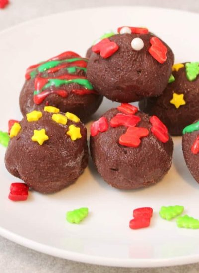 Chocolate Christmas truffles on a white plate.