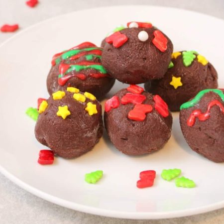 Chocolate Christmas truffles on a white plate.