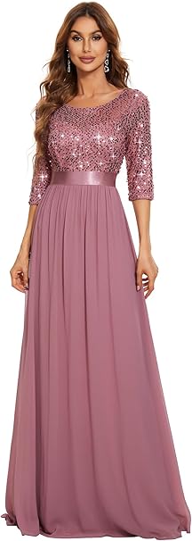Woman in a long mauve dress with sequined top and three-quarter sleeves, standing against a plain white background.