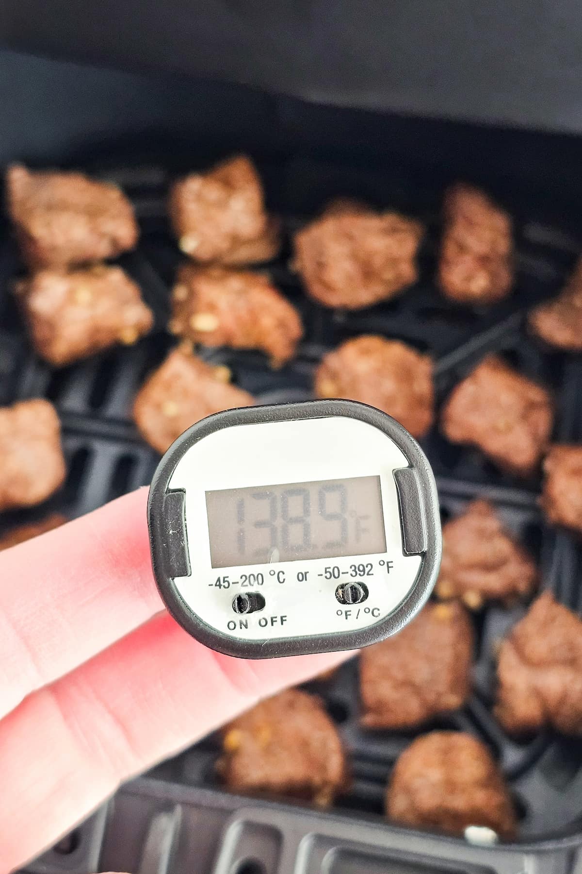 A digital thermometer shows 139.8°F next to grilled meat pieces, reminiscent of perfectly cooked air fryer steak bites.