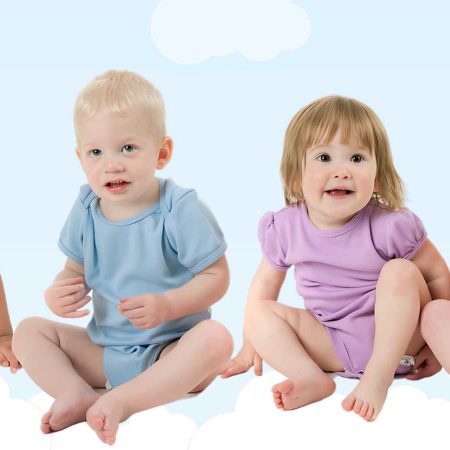 Four toddlers sit on a cloud-like background, each wearing a different colored onesie: blue, light blue, purple, and pink.