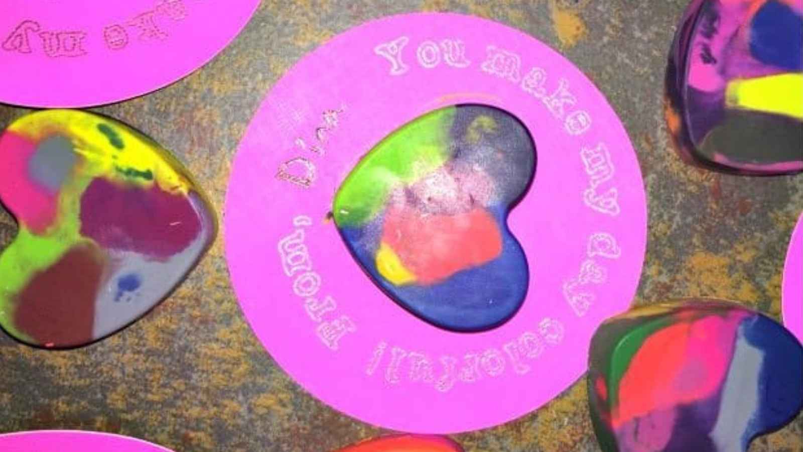Colorful heart-shaped crayons on a pink card with text: "You make my day colorful.