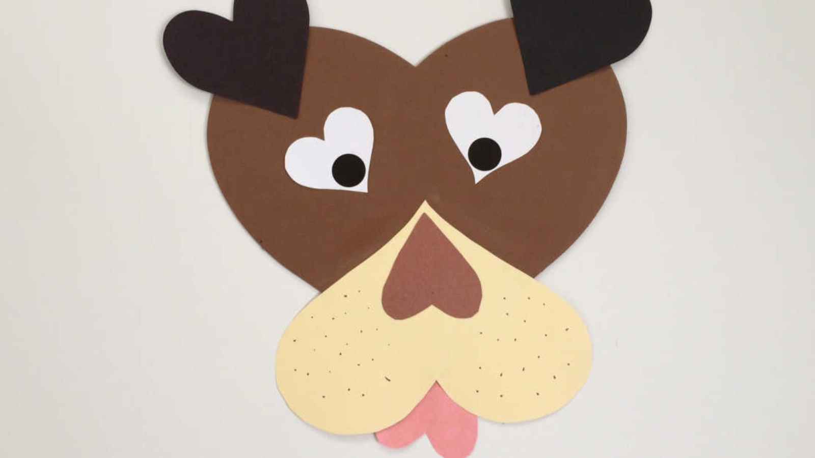Heart-shaped paper craft resembling a dog's face with heart eyes and a heart-shaped nose.