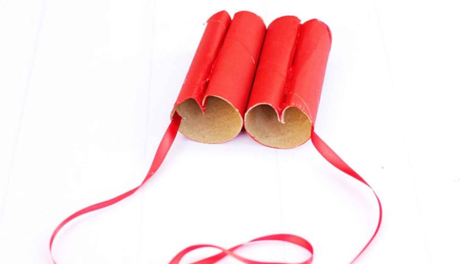 Red cardboard binoculars made from paper rolls, tied with a matching ribbon.