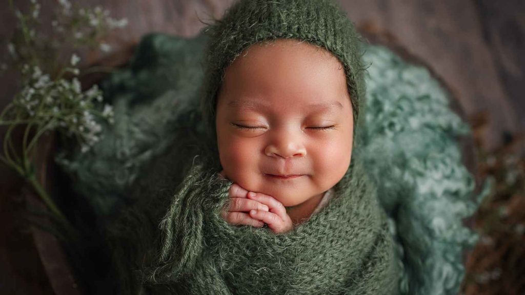 Baby boy with green background.