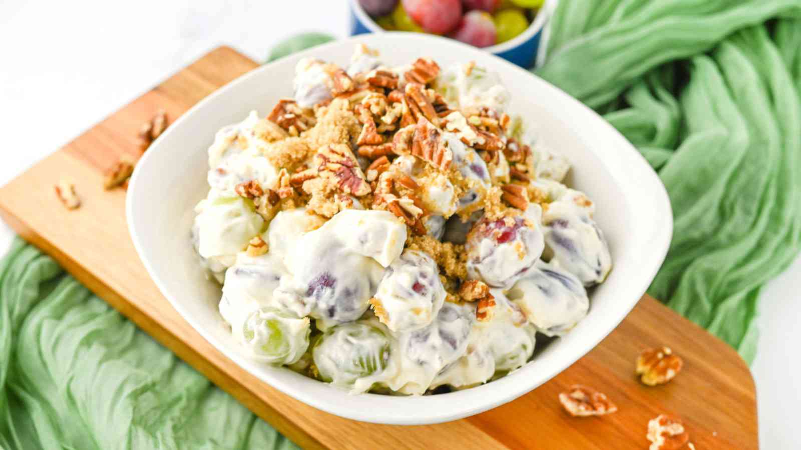 Creamy grape salad in a white serving bowl.