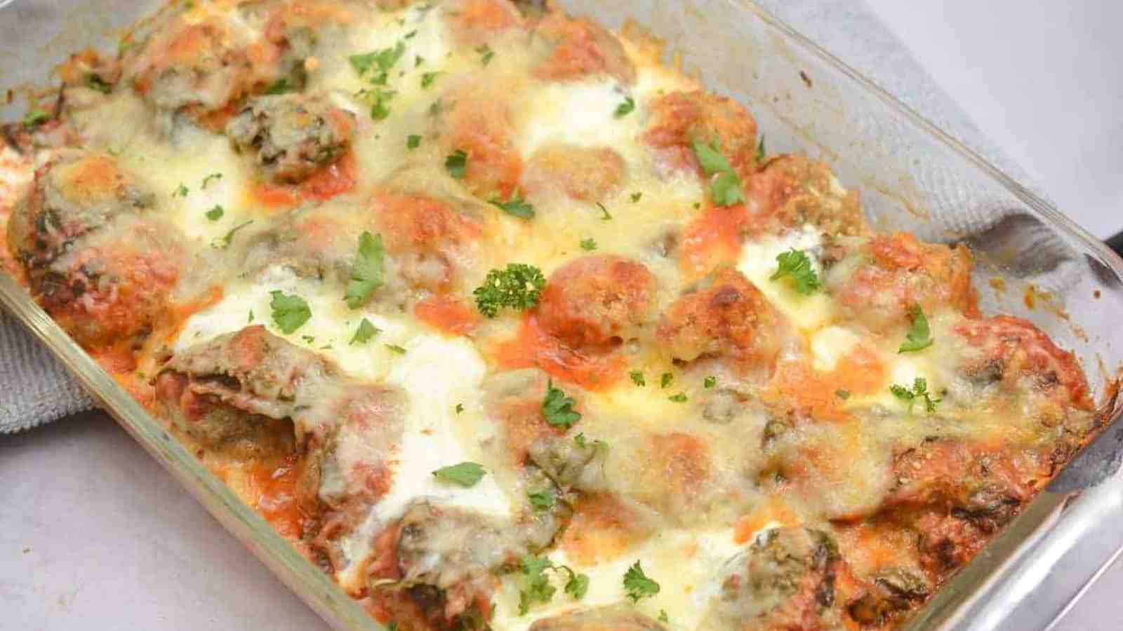 A casserole dish filled with meatballs and cheese.
