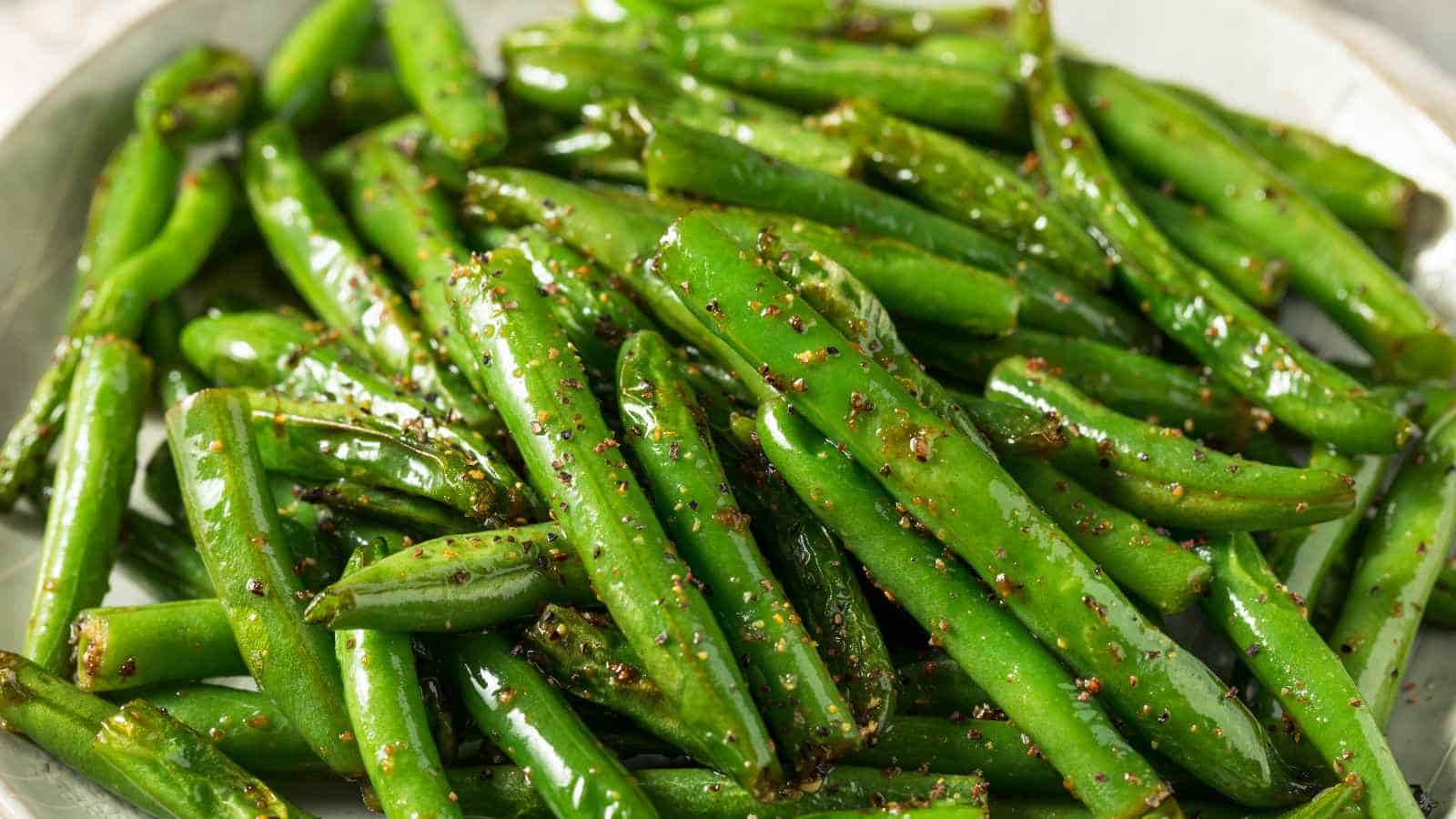 A plate of seasoned green beans glistening with oil.