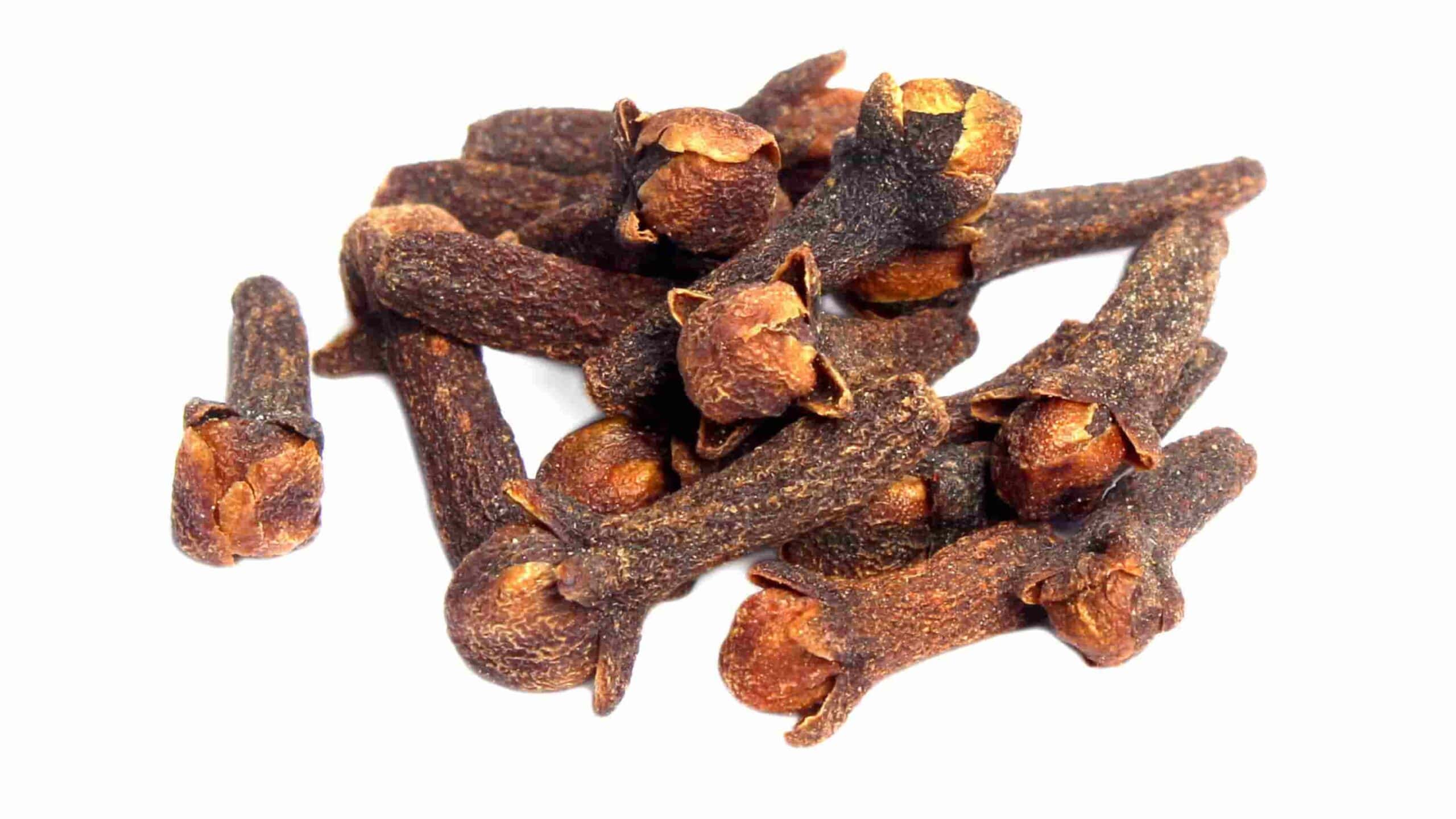 A small pile of dried whole cloves is shown on a white background.