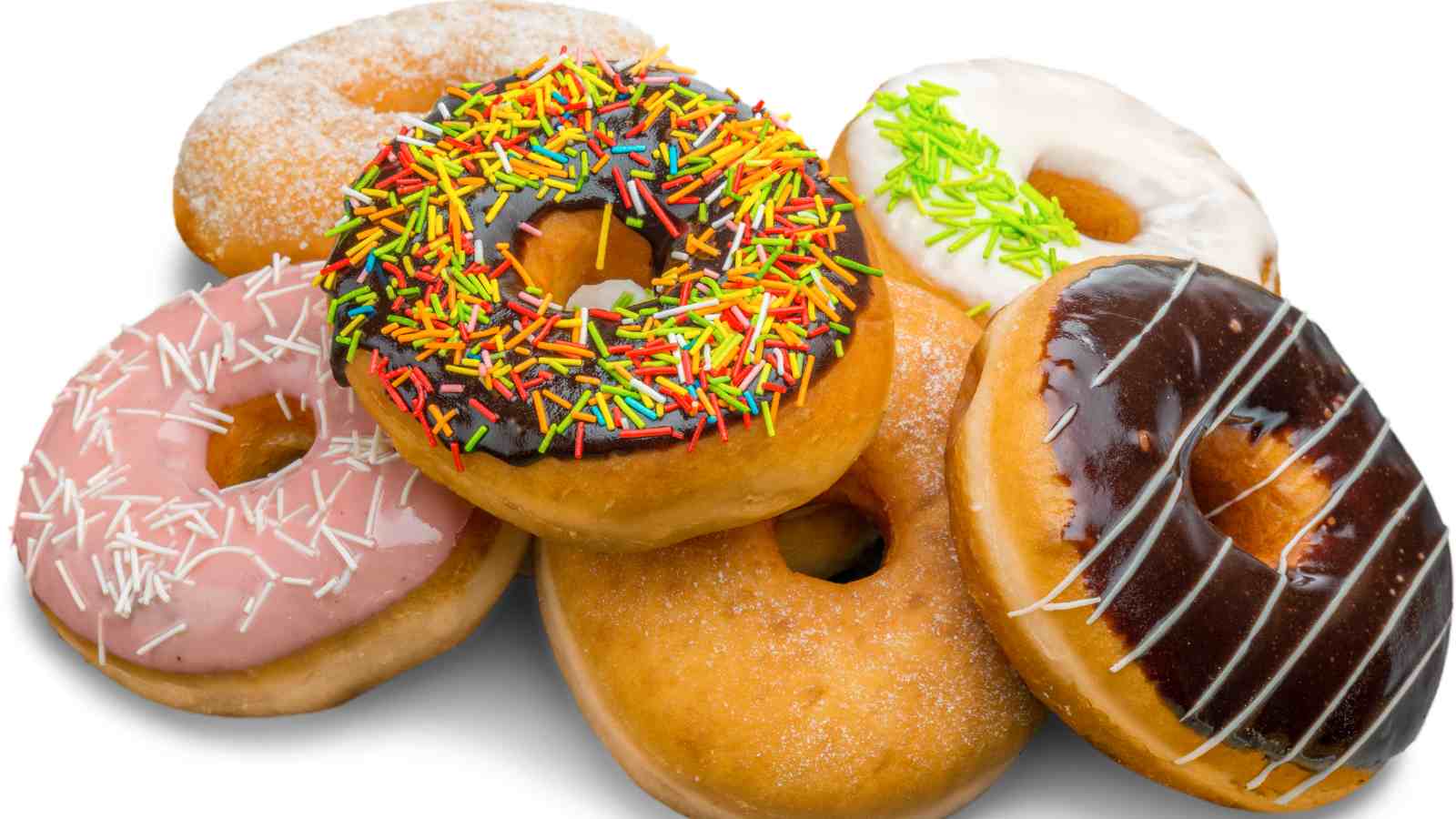 A group of six assorted donuts with various icing, sprinkles, and toppings, arranged closely together on a white background.