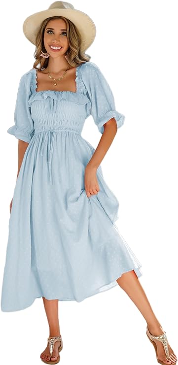 A woman wearing a light blue, off-shoulder, puff-sleeve midi dress, straw hat, and sandals stands smiling with one hand holding her dress.