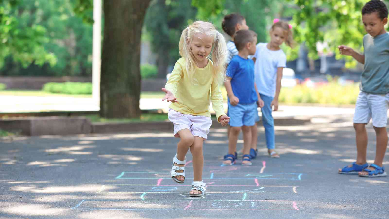 Children playing on a sidewalk with chalk