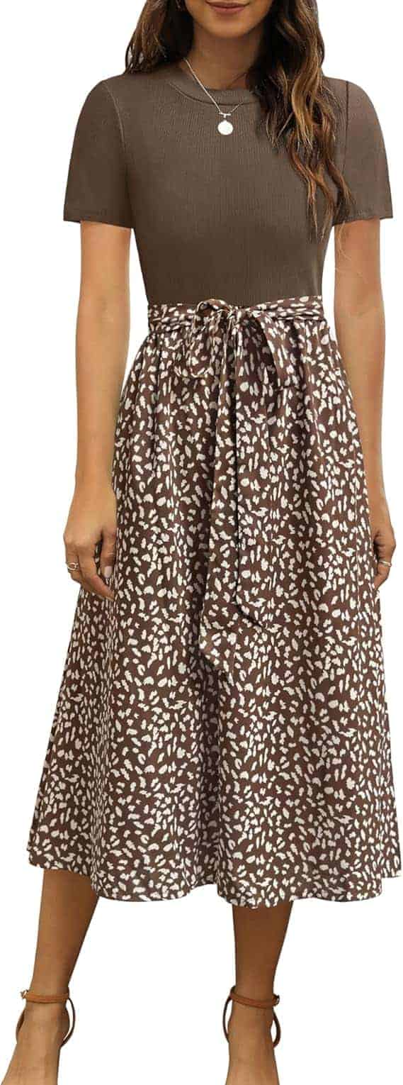 Woman wearing a short-sleeve brown top with a matching brown and white patterned midi skirt, tied at the waist with a bow.