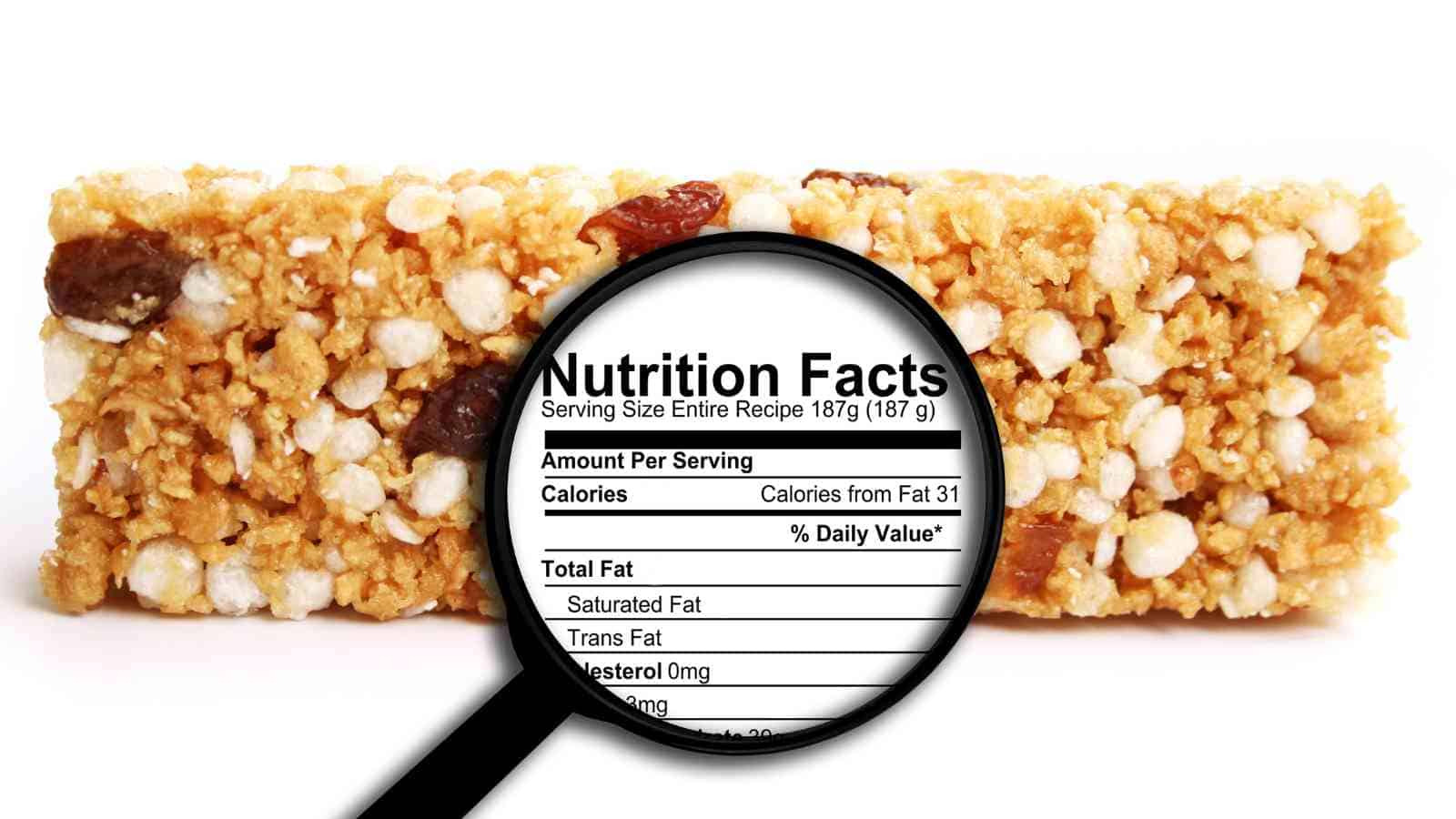 A granola bar with a magnifying glass focusing on its nutrition facts label.