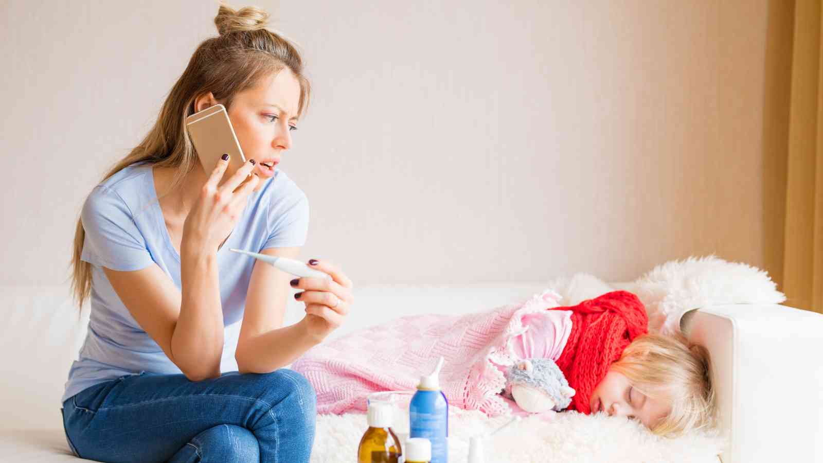 Mom calling someone on the phone. Beside her is a little girl, not feeling well.