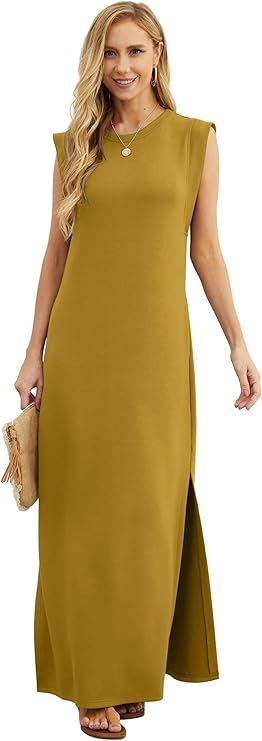 A woman wearing a sleeveless mustard yellow maxi dress with a side slit, holding a beige clutch and standing against a white background.