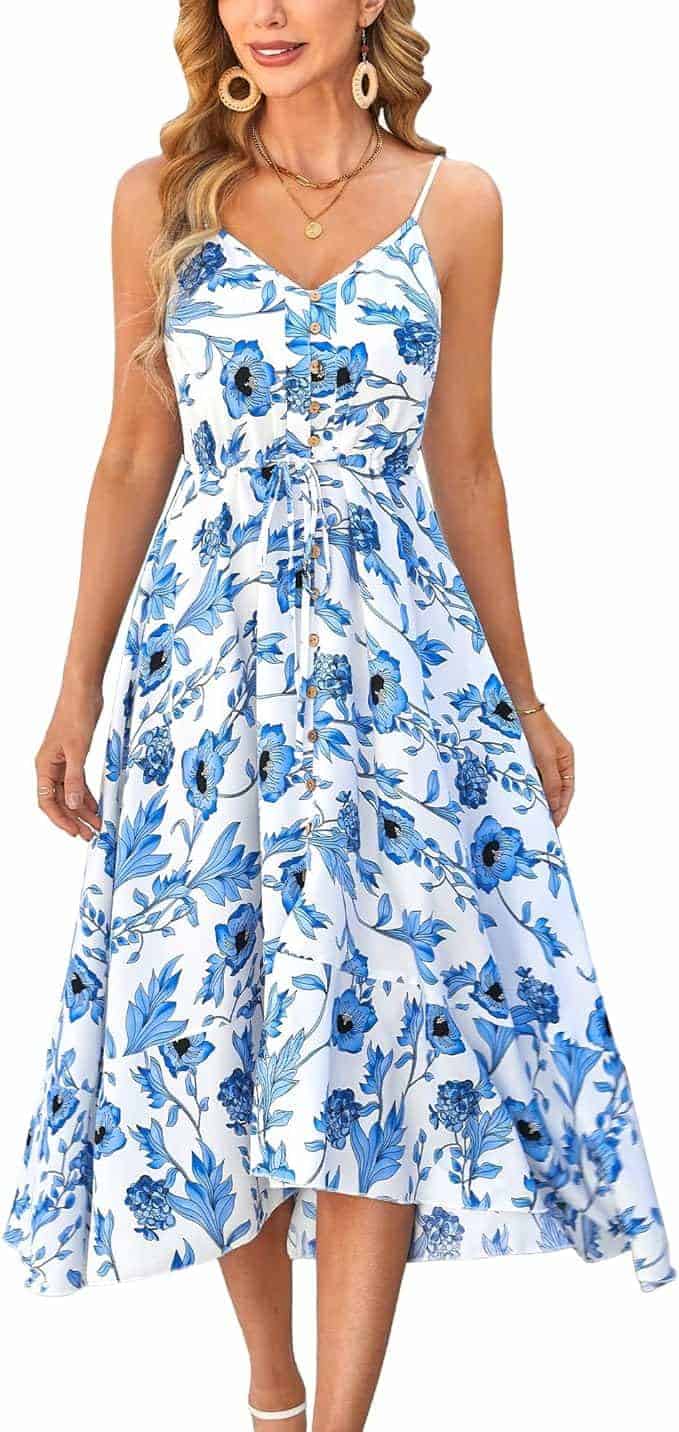 Woman wearing a white sleeveless dress with blue floral print, button-down front, waist tie, and a flared, calf-length skirt.