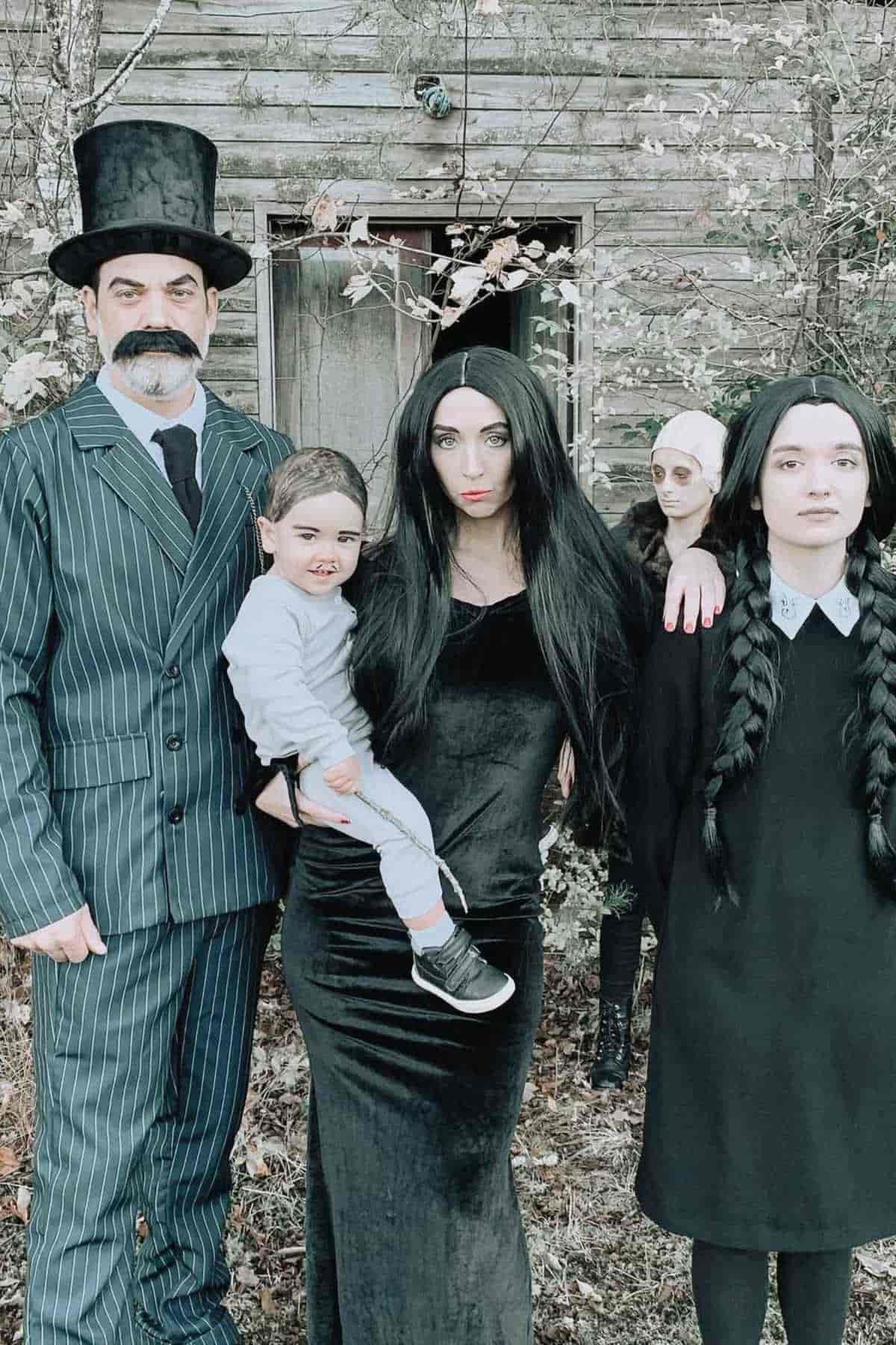A family of five wearing as "The Addams Family" costumes.