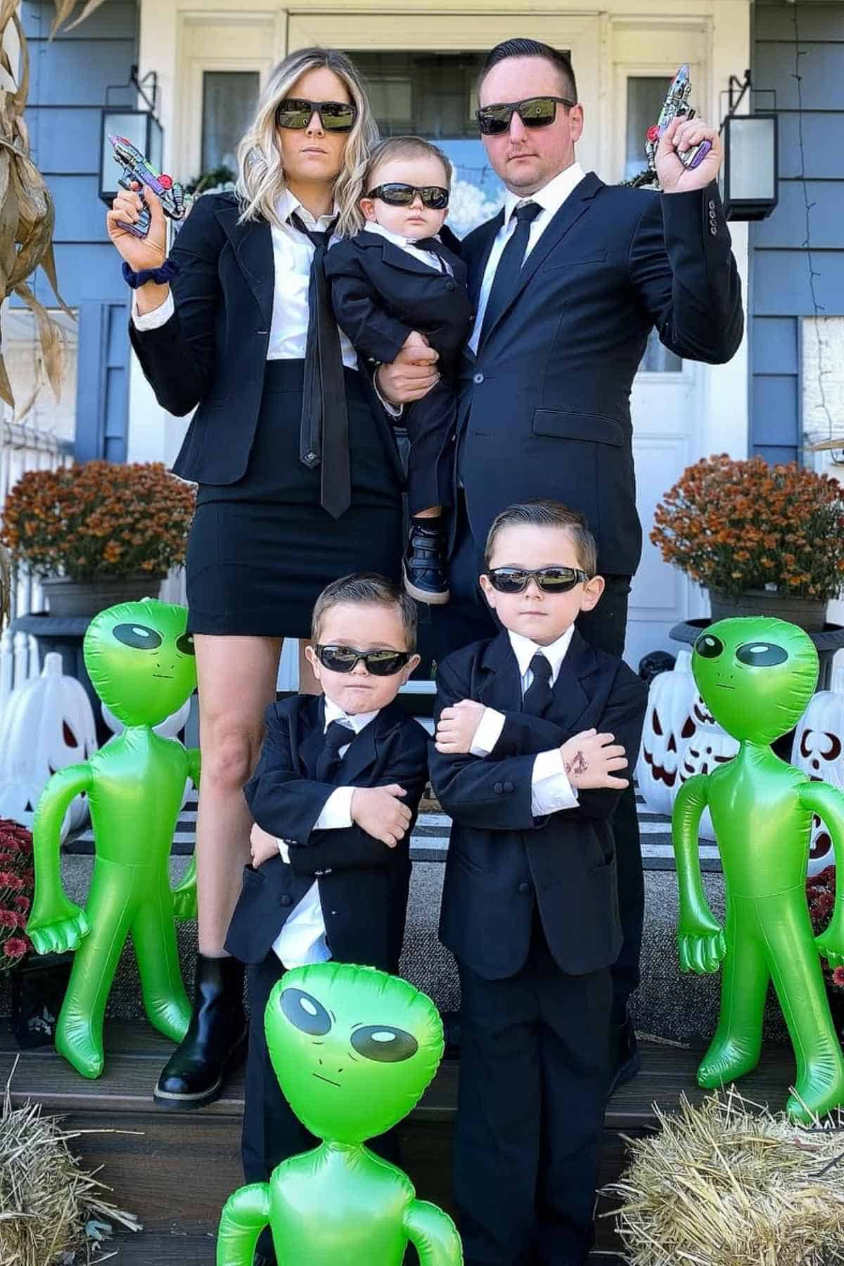 A family of five wearing costumes inspired by men in black.