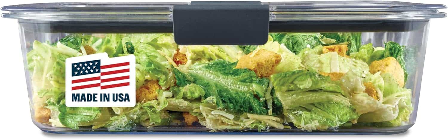 A clear large food storage container with a salad inside.