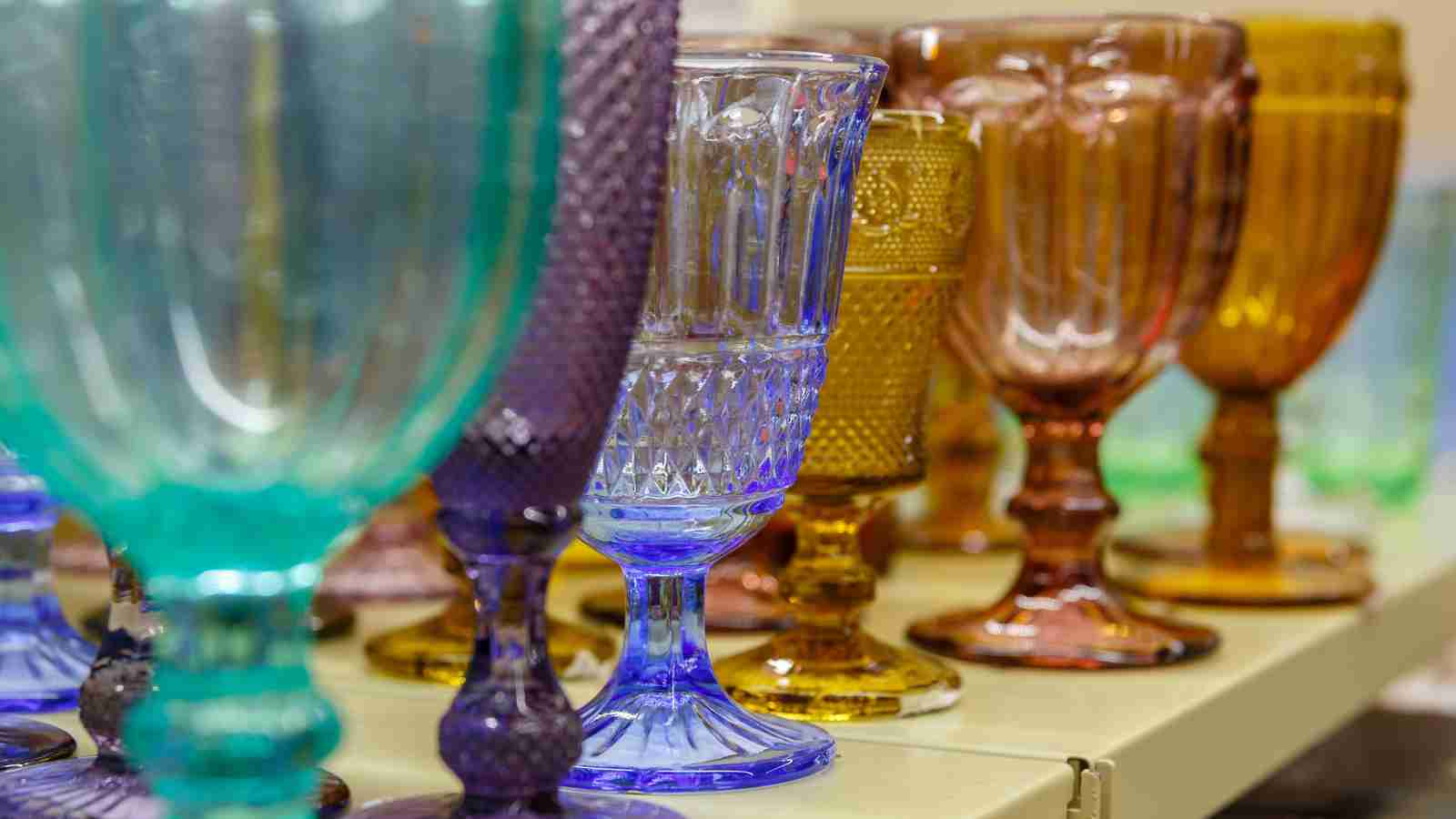 A shelf displays a collection of colorful vintage goblets.