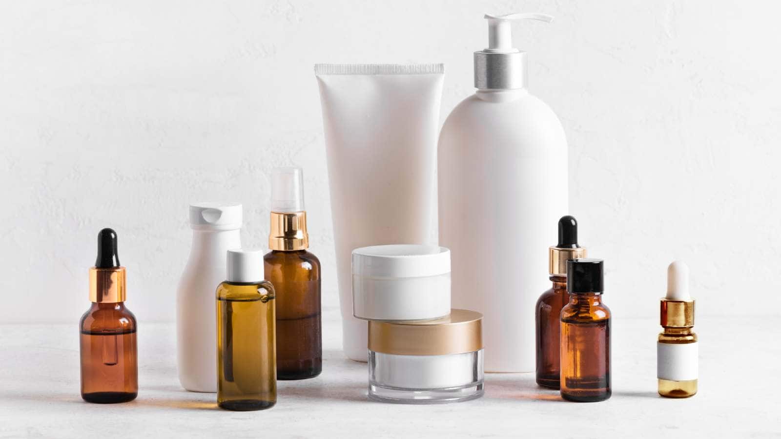 Various skincare products, including bottles, jars, and tubes, are arranged on a white surface.