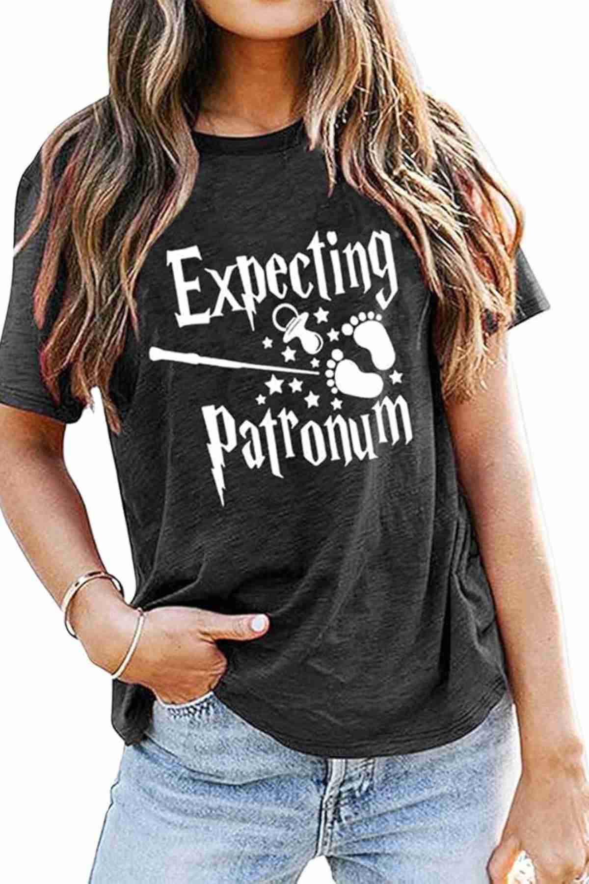 A woman wearing a black t-shirt with the text "Expecting Patronum" and a wand graphic, referencing a Harry Potter theme.