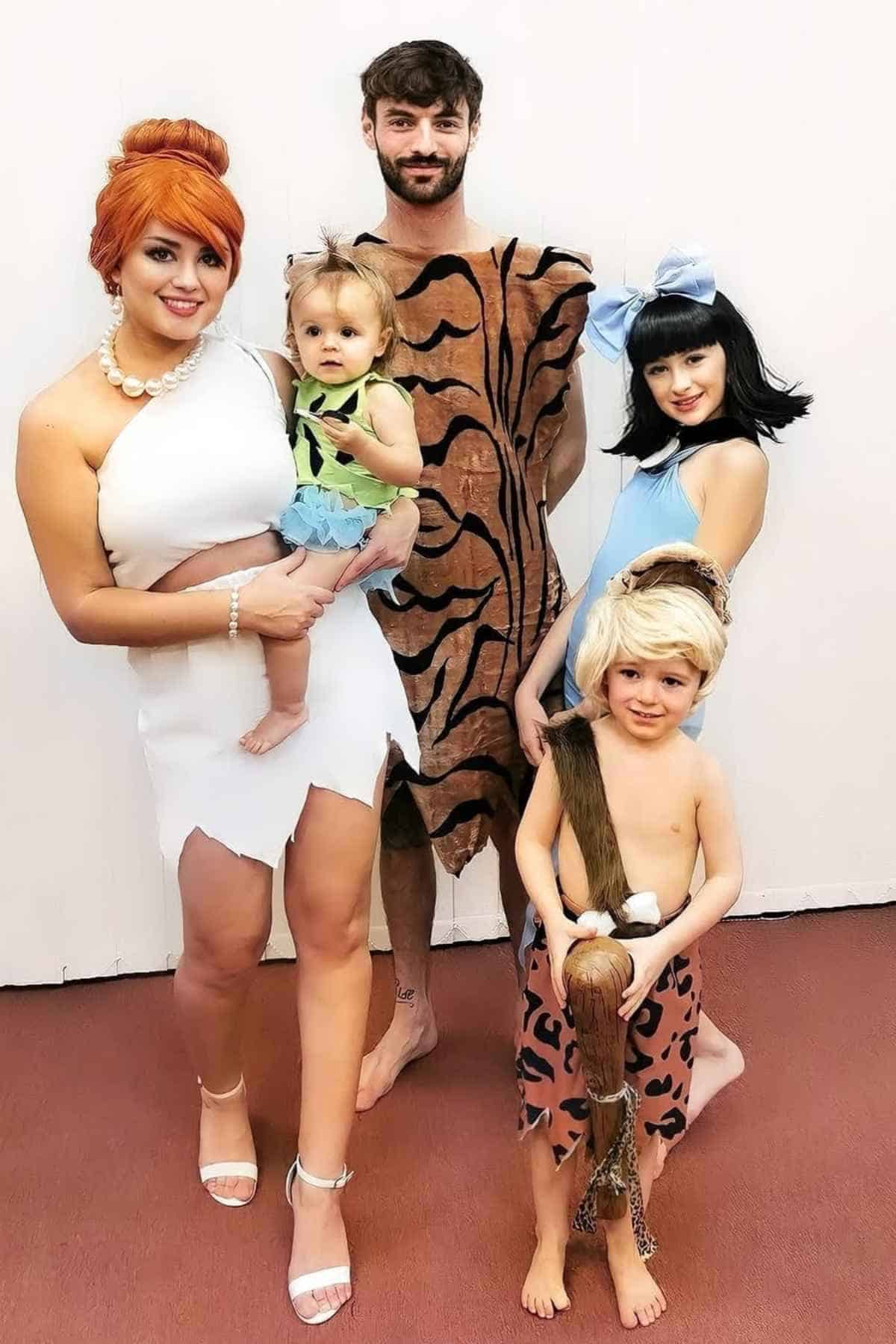 A family of five wearing costumes inspired by "The Flintstones".