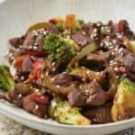 Venison stir fry served on a white textured plate.