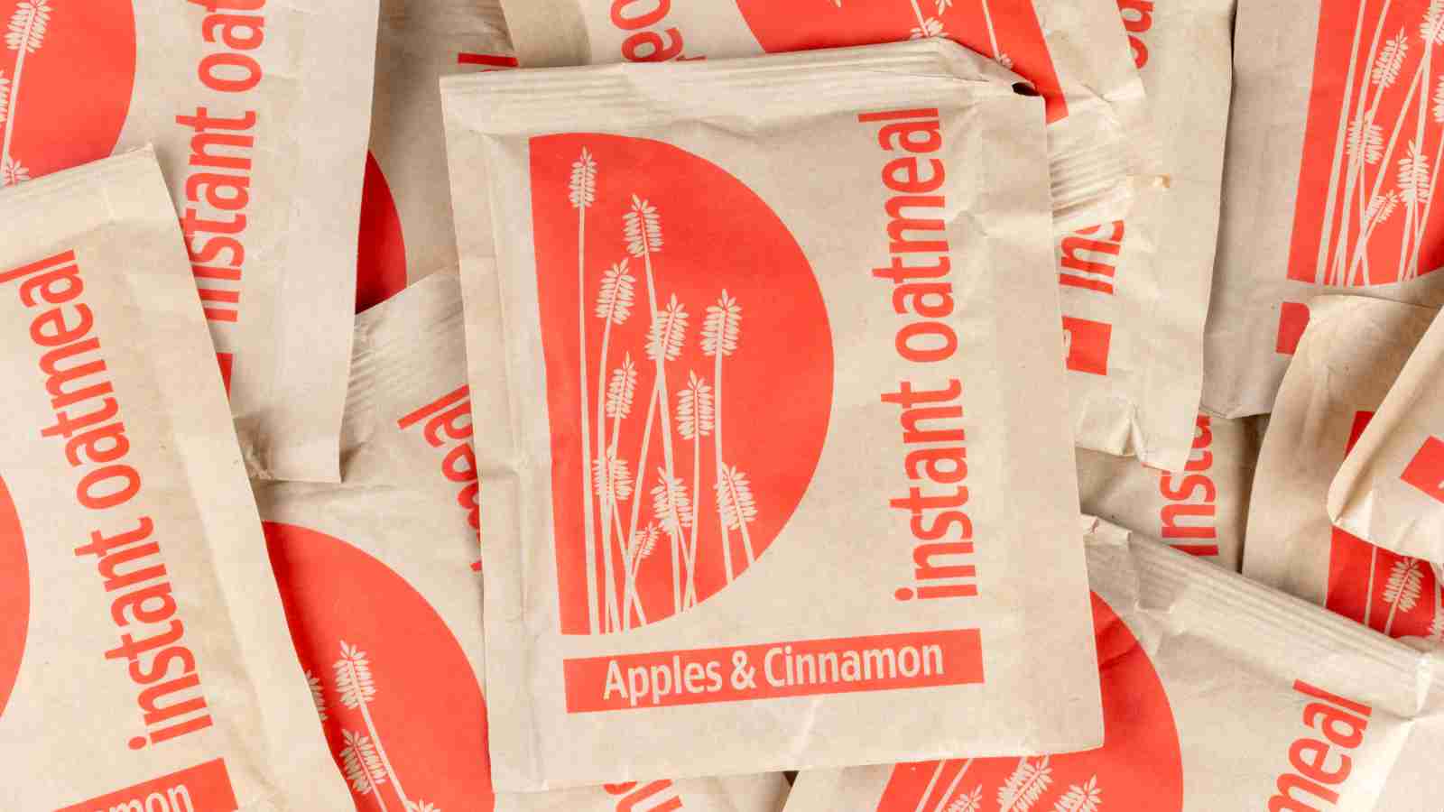 Several packets of instant oatmeal labeled "Apples & Cinnamon" are stacked together, featuring a red design with wheat stalks on the packaging.