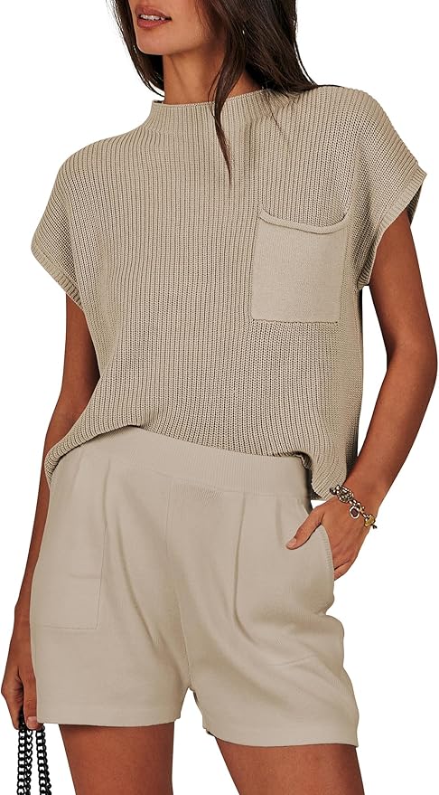 A woman wearing a beige short-sleeve knit top with a pocket, paired with high-waisted beige shorts, standing with one hand in her pocket.