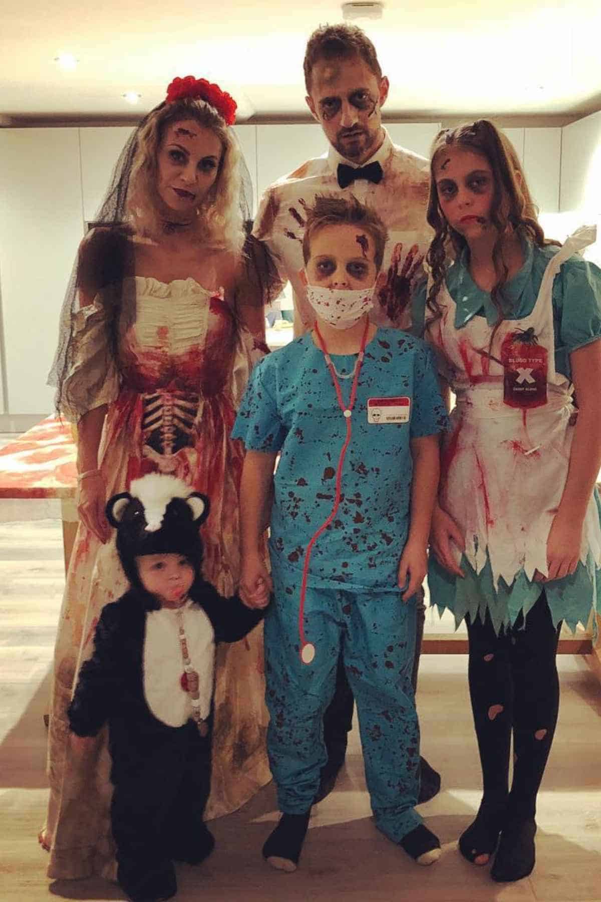 A family of five wearing costumes with bloods, imitating characters from The Living Dead.