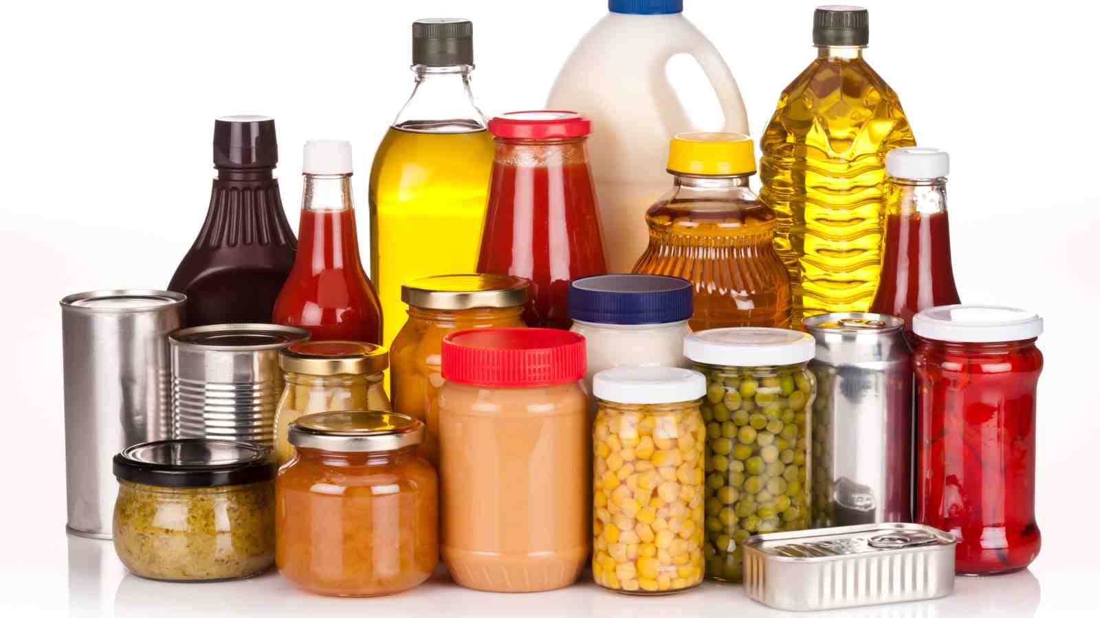 A variety of canned and bottled food items, including oils, sauces, and vegetables, are arranged together on a white background.