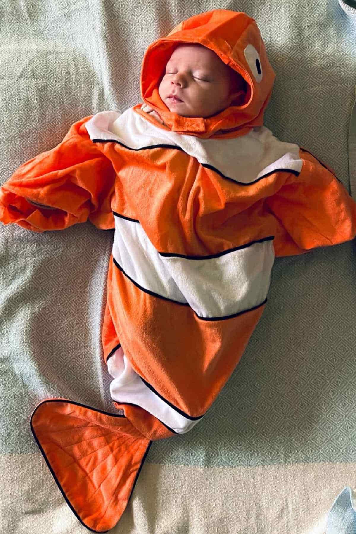 A baby dressed as the famous clownfish character nemo.