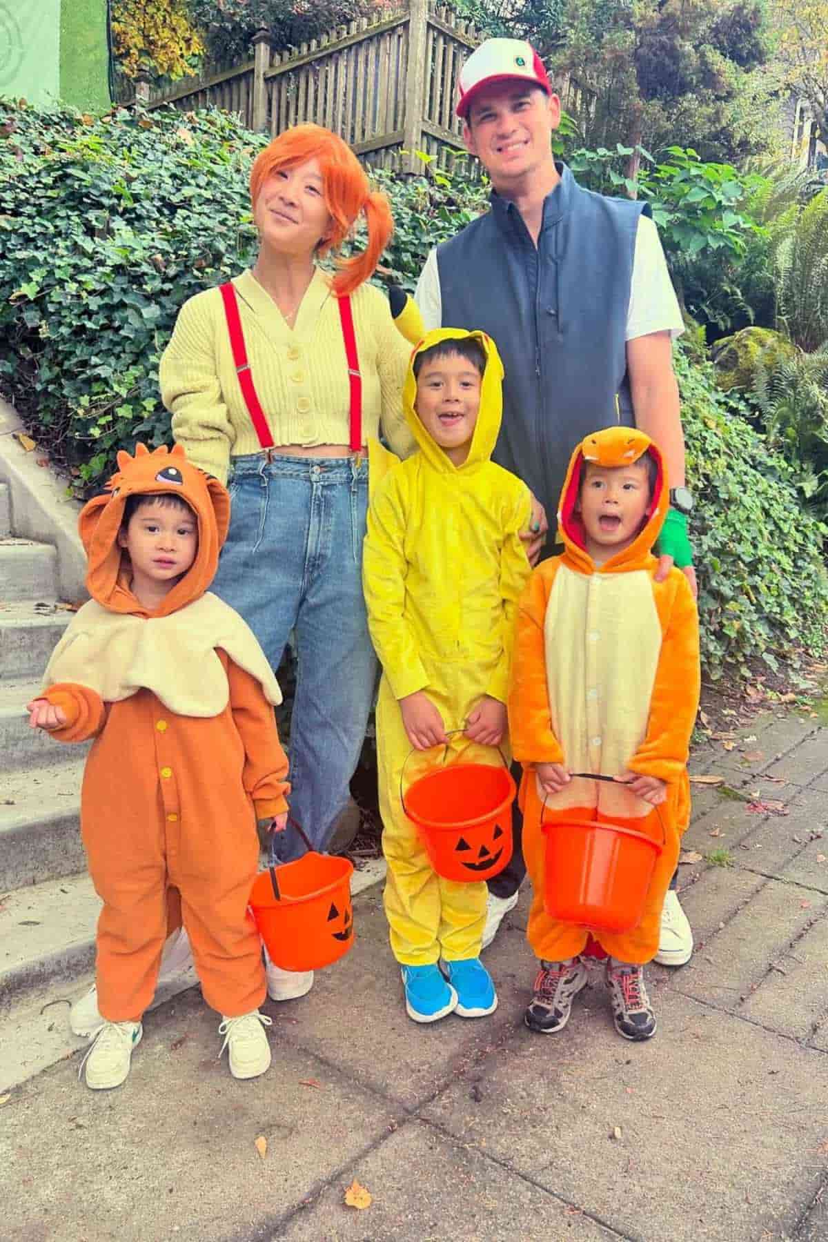 A family of five wearing Pokemon costumes, standing near the stairs.