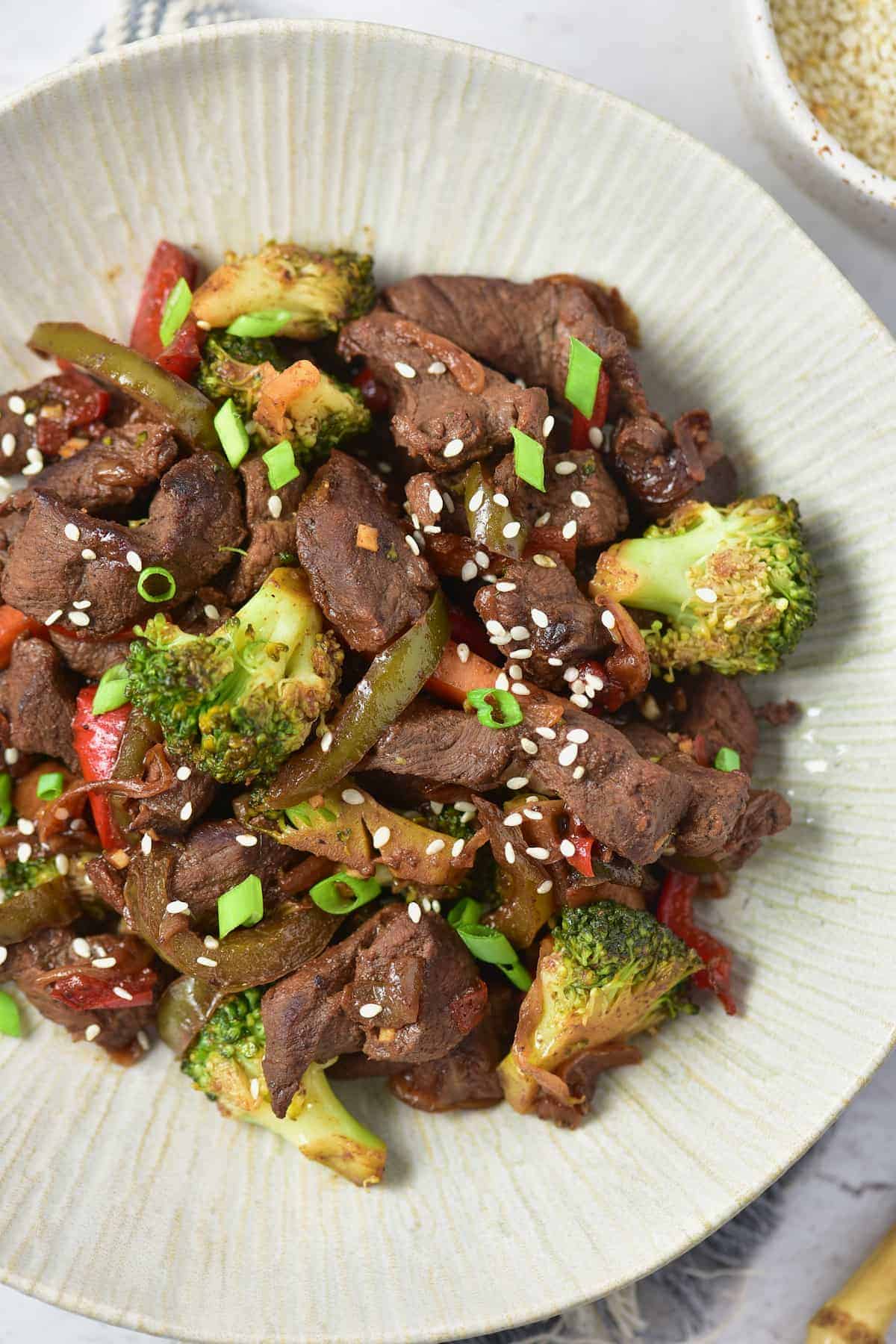 Top view of venison stir fry beautifully served on a white textured plate.