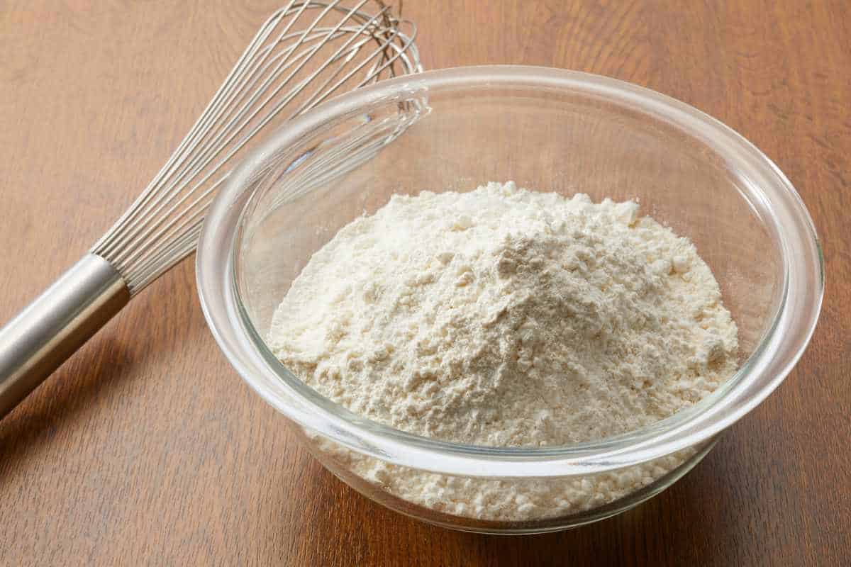 Flour in a mixing bowl with a whisk.
