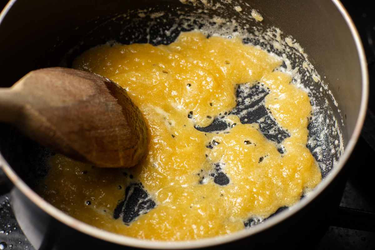 Making roux in a pan with a wooden serving spoon.