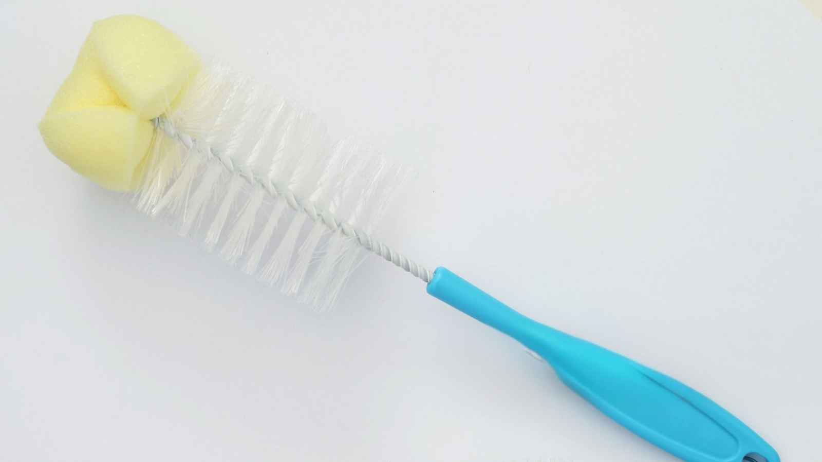 A cleaning brush with white bristles, a yellow sponge tip, and a blue plastic handle on a white background.