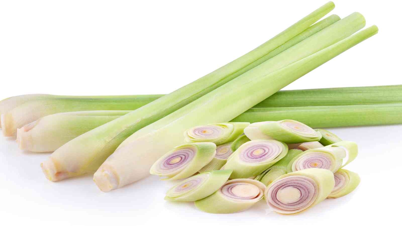 Three whole lemongrass stalks and several sliced pieces are arranged on a white background.