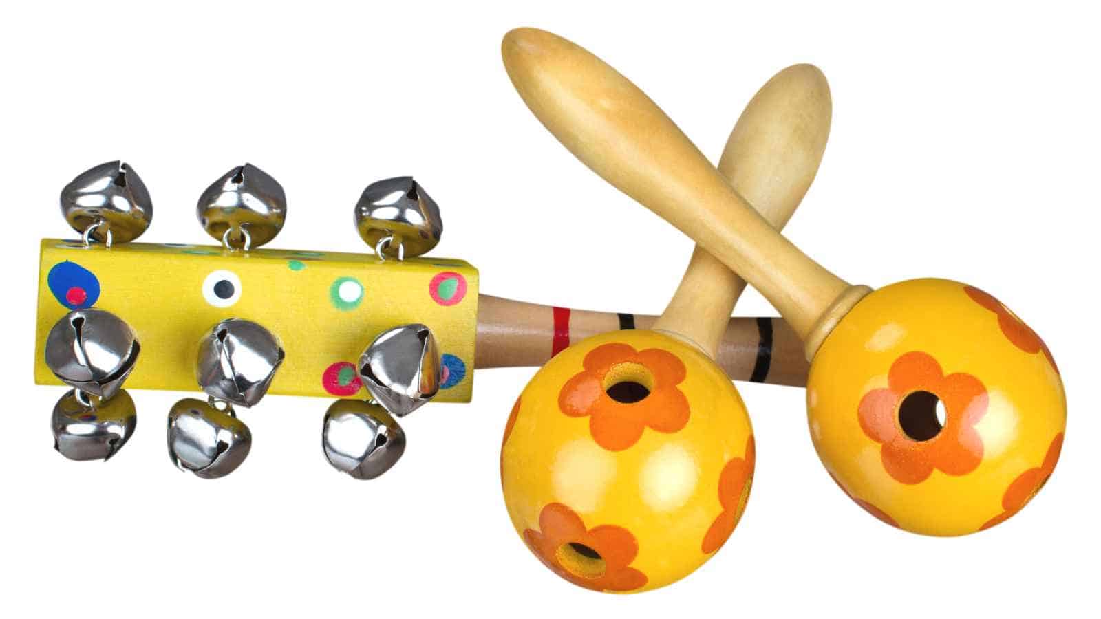A pair of wooden maracas with orange flower designs and a small yellow handheld percussion stick decorated with silver bells.