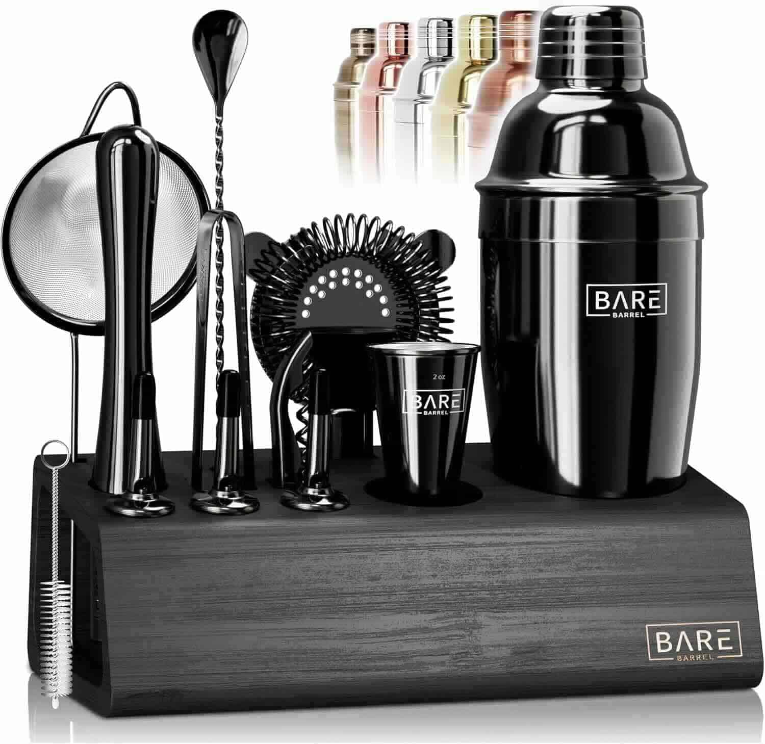 A black cocktail shaker set with various bar tools, a jigger, and a strainer, all arranged on a wooden stand. Multiple metallic shaker colors appear in the background.