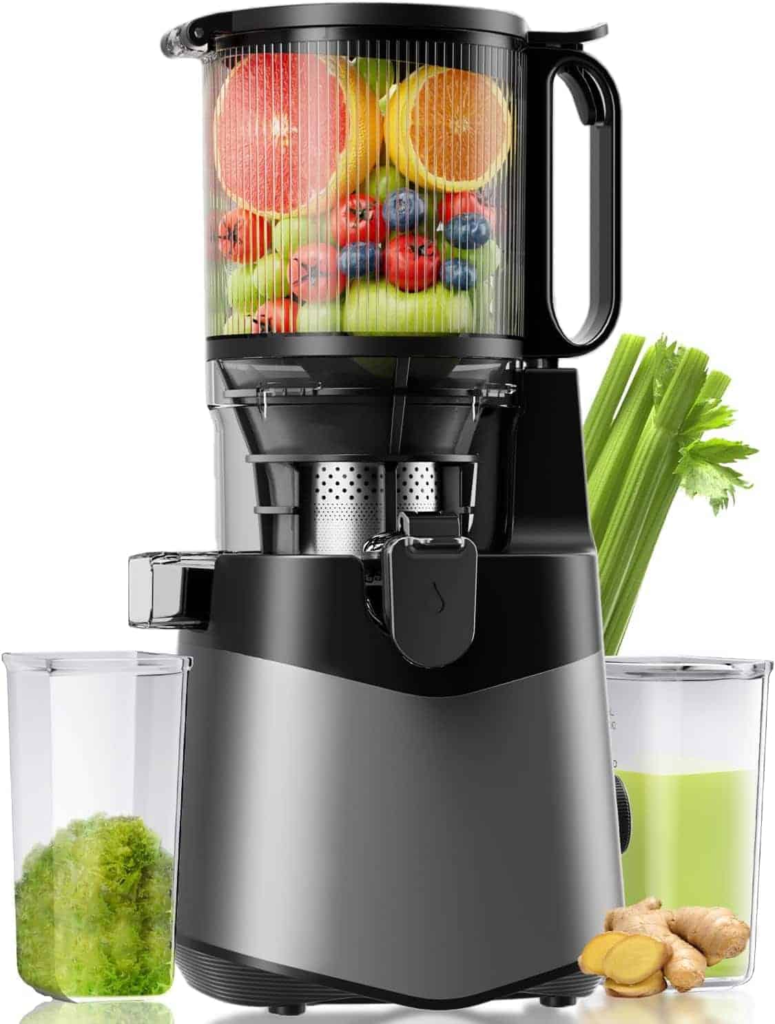 A black juicer filled with assorted fruits stands on a counter, with a glass of green juice, celery stalks, ginger, and a cup of pulp beside it.